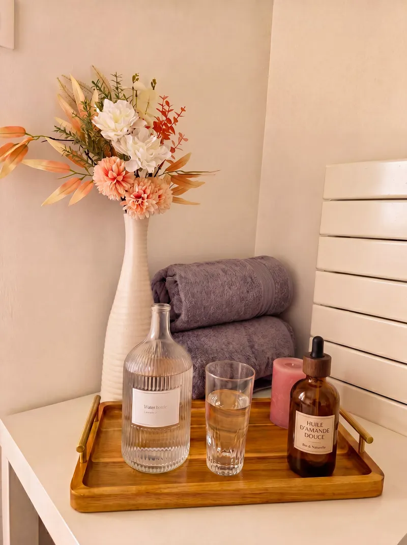 Le plateau d'accueil du studio : carafe d'eau, huile d'amande douce bio et serviettes moelleuses